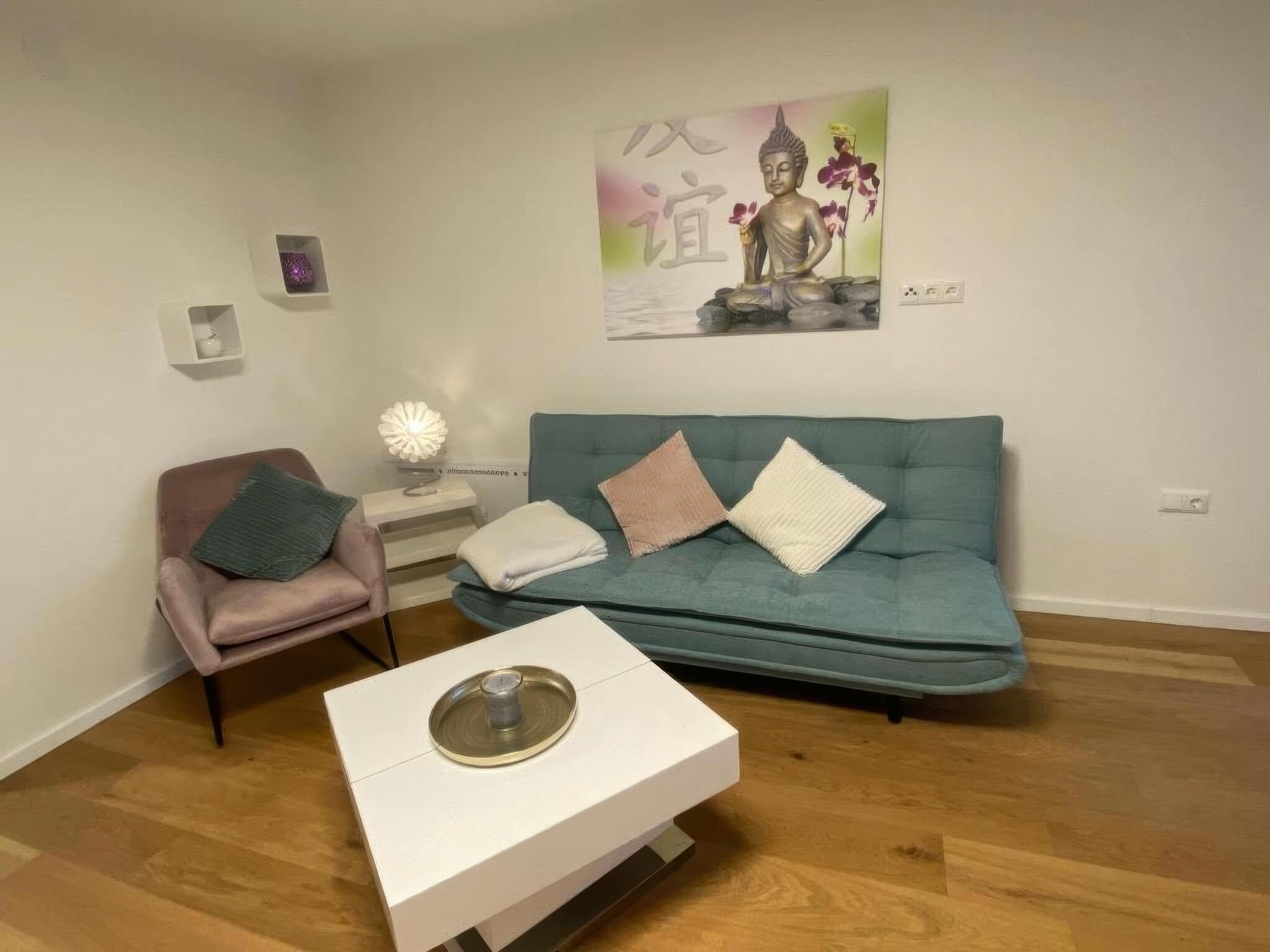 Ein gemütliches Wohnzimmer mit Buddha-Poster, moderner Couch und elegantem Couchtisch – perfekte Entspannungsoase.